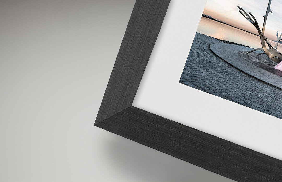 Framed photograph with a black frame on a light gray background, shown to illustrate framing type. 